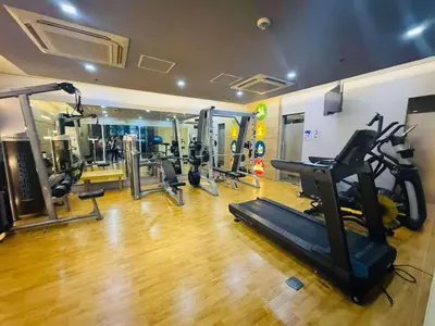 a gym with several treadmills and machines in a room at Lovely Condo Across NAIA T3 Newport with WiFi in Manila