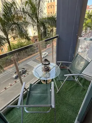 a glass table and chairs on a balcony with a street at Lovely Condo Across NAIA T3 Newport with WiFi in Manila