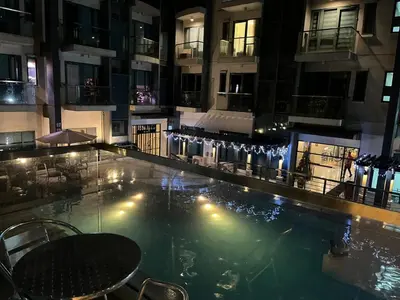 a large swimming pool in a building at night at Kyendenz Condotel-Across Naia T3 Pool View with Wifi in Manila