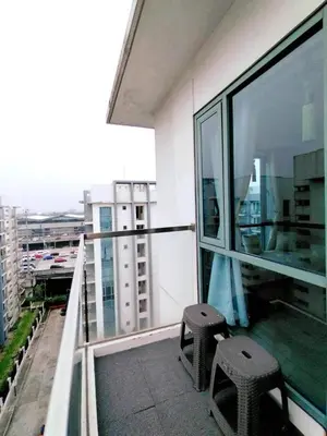 a balcony with a pair of stools on a building at Staycation Unit at Two Palm Across Naia T3 with WIFI in Manila
