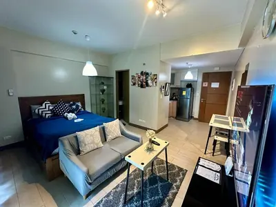a living room with a bed and a couch at Studio Unit Across NAIA T3 Airport MNL in Manila