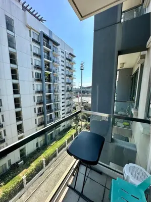 a black chair sitting on the balcony of a building at Studio Unit Across NAIA T3 Airport MNL in Manila
