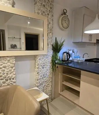a kitchen with a counter and a clock on the wall at Staycation in Paranaque by Indigo in Manila