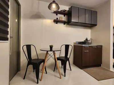 a kitchen with a table and chairs in a room at MetacasaStaycations-beside EK with Fireworks view in Santa Rosa