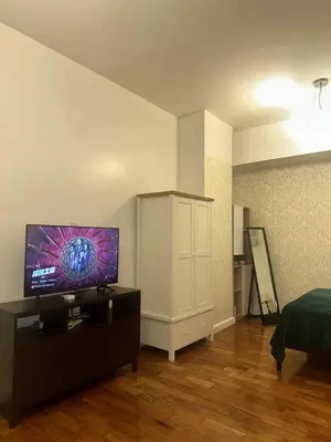 a living room with a flat screen tv on a cabinet at Spacious Studio in Mosaic Tower no Balcony in Manila