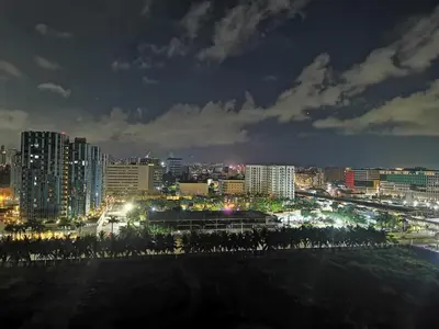 a city lit up at night with buildings at Mall of Asia condotel shore 3 residence in Manila