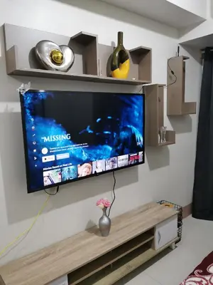 a flat screen tv hanging on a wall at Mall of Asia condotel shore 3 residence in Manila