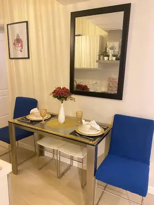 a dining room table with blue chairs and a mirror at Azure Staycations by MM 1 in Manila