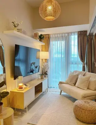 a living room with a couch and a tv at Cozy & Stylist Unit in BGC in Manila