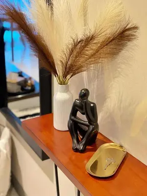 a black cat statue sitting on a table with a vase at Cozy Netflix and Chill in BGC in Manila