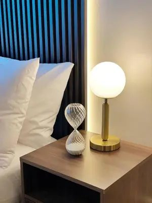 a lamp on a table next to a bed at Netflix and Chill Cozy Unit BGC in Manila