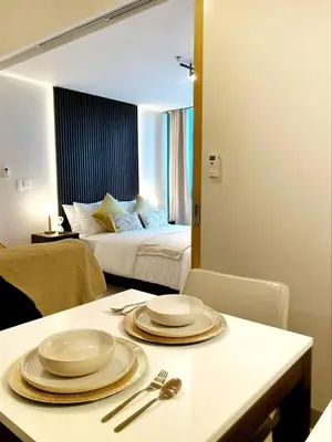 a room with a bed and a table with plates on it at Netflix and Chill Cozy Unit BGC in Manila