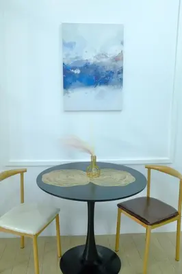 a table with two chairs and a painting on the wall at Chill Luxe Vista in Manila