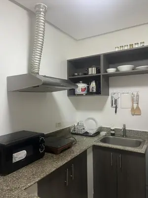 a kitchen with a sink and a microwave at JFS Home at Birch Tower in Manila
