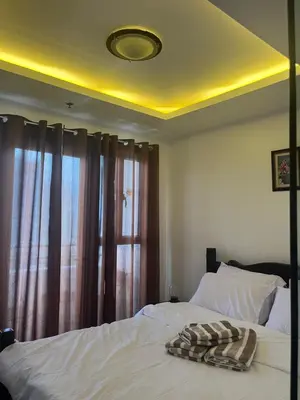 a bedroom with a white bed with a window at JFS Home at Birch Tower in Manila