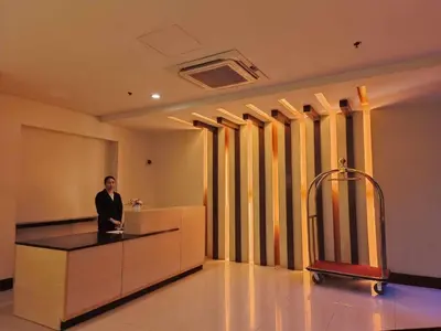 a man standing at a reception desk in a lobby at Affordable Condoatel Hotel Near Naia 1,2,34 in Manila