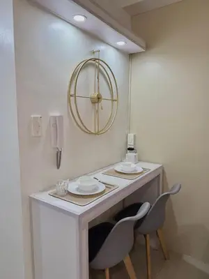 a table with two chairs and a mirror on the wall at Cozy Condo Staycation with Balcony near Mall of Asia in Manila
