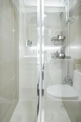 a white bathroom with a shower and a sink at The Sunny Flat at Fame Residences near SM Megamall, Shangrila in Manila