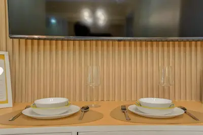 a table with two bowls and plates on a table at The Sunny Flat at Fame Residences near SM Megamall, Shangrila in Manila