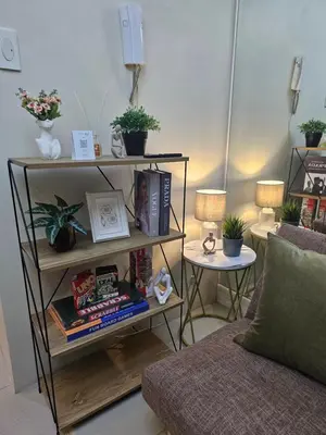 a living room with a book shelf with books at MOA Shell Residences Spacious 1BR with City View WiFi and Netflix in Manila