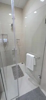 a bathroom with a shower with a glass door at Explore Mitsukoshi Uptown BGC, large TV, fast WIFI in Manila
