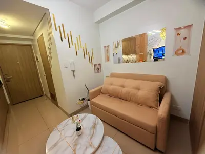 a living room with a couch and a table at Shore 2 Residences Tower 3 by HappyHaven in Manila