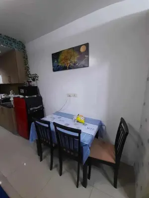 a kitchen with a table and chairs in a room at Shore Residences Tower B near MOA and IKEA Pasay City in Manila