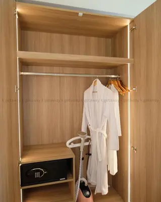 a closet with wooden walls and a door with a robe at Acqua at The Hotel Residences Acqua Manila near Makati and BGC in Manila