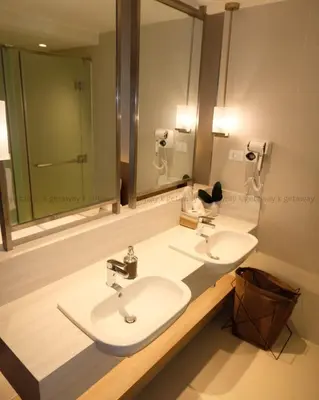 a bathroom with two sinks and a large mirror at Acqua at The Hotel Residences Acqua Manila near Makati and BGC in Manila