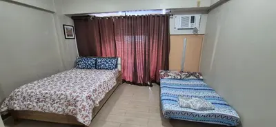 a small bedroom with a bed and a window at Rqui Condotel Newport Pasay City in Manila