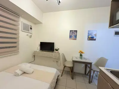 a small room with a bed and a table with a television at JJMC HOMESTAY 29 with Netflix and Wifi in Manila