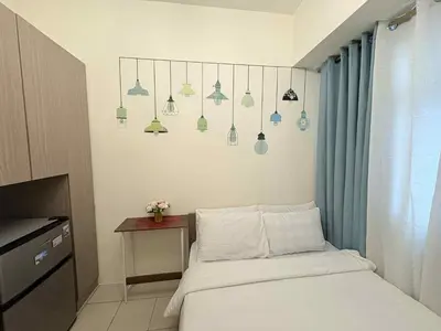 a bedroom with a bed and a table and some lights at JJMC PLACE 29 With Netflix and Unli Wifi in Manila
