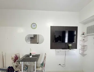 a white room with a table and a clock on the wall at JJMC PLACE 36 With Netflix and Unli Wifi in Manila