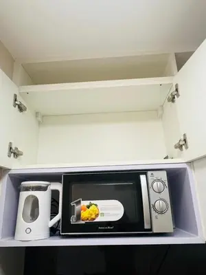 a microwave sitting on a shelf in a kitchen at Astra Heights Staycation in Manila