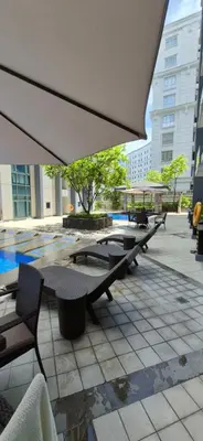 a group of tables and chairs under an umbrella at Rooms in Pasay Manila Nearest To Airport Terminal 3 in Manila
