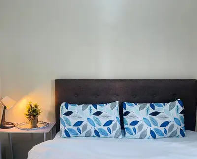 a bedroom with a bed with blue and white pillows at Rose 150newport pasay in Manila