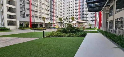 a lawn in the middle of a courtyard with tall buildings at In My Jib Sucat in Manila