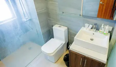 a bathroom with a toilet and a sink and a shower at Spacious Condo with 50in TV & Netflix, Near Malls in Manila