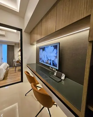 a desk with a computer and chairs in a room at Luxury apartment at Park McKinley West suite 1 in Manila