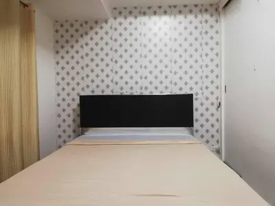 a bed in a room with a wall at Grand Riviera Condotel Near St lukes Medical Center in Manila