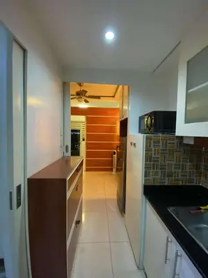 a kitchen with a counter and a ceiling fan at MJ&J Breeze Staycation in Manila