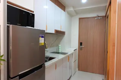 a kitchen with a stainless steel refrigerator and a door at F&M Deluxe Holiday Suite MOA SHORE 3 Residences