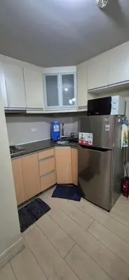 a kitchen with a stainless steel refrigerator and cabinets at Condotel in Pasay City Manila in Manila