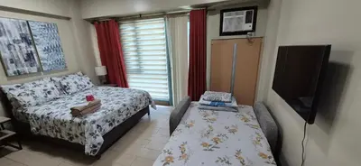 a bedroom with a bed and a flat screen tv at Condotel in Pasay City Manila in Manila