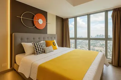 a bedroom with a large bed with a clock on the wall at Elegant and Modern 3BR Penthouse in Uptown BGC in Manila