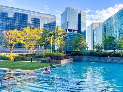 people floating in a pool in a city with tall buildings at Elegant and Modern 3BR Penthouse in Uptown BGC in Manila