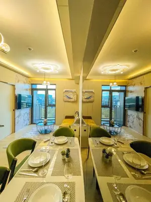 a dining room with tables and green chairs at Modern 1BR Stay near Solaire, Okada, near Airport in Manila