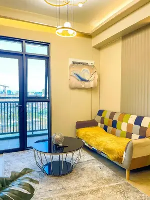 a living room with a couch and a table at Modern 1BR Stay near Solaire, Okada, near Airport in Manila