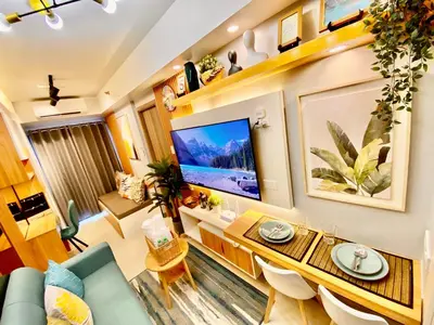 a living room with a large flat screen tv at Calix Suite in Manila