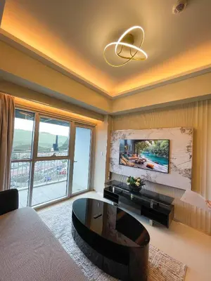 a living room with a couch and a table at Luxury and Modern 1 Bedroom near Solaire, Okada in Manila